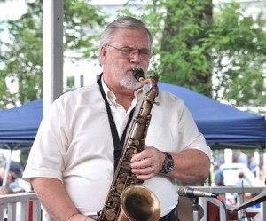 Kelly Clark plays saxophone from the bandstand.