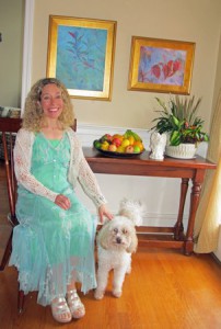 Artist Allison Picone, with her dog Felix, in front of some of her recent paintings. (Photo/Joyce DeWallace)