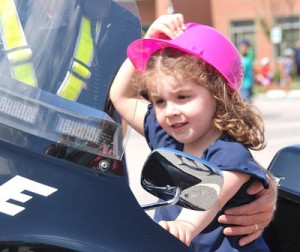 Alice DeBiase, 3, holds onto her hat while seated on a Grafton Police Department’s motorcycle.