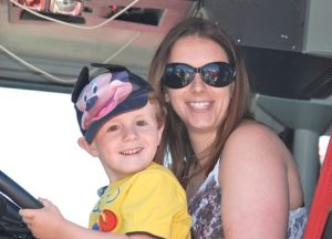 Peyton Bennett, 3, and his mother Jessica pose for a photo from inside a fire truck.