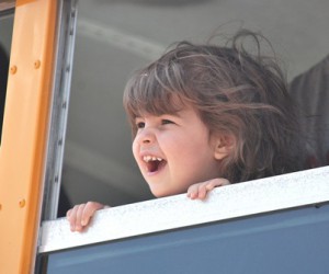 Madison DeCabe, 3, takes a look from a school bus window.