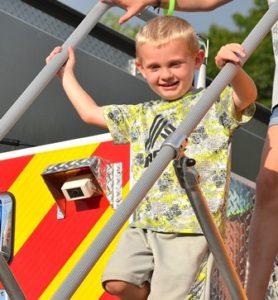 Brian Hale, 4, climbs down from the Grafton Fire Department rescue truck.