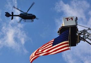 A State Police helicopter flies over the Grafton Police Headquarters grounds.