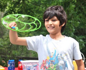 Aansh Patel, 7, waves a bubble wand.