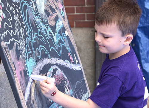Andrew Murphy, 6, draws on a community art canvas. Photos/Ed Karvoski Jr.