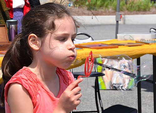 Maria Carrara, 8, blows bubbles in the Main Street Bank parking lot. Photos/Ed Karvoski Jr.