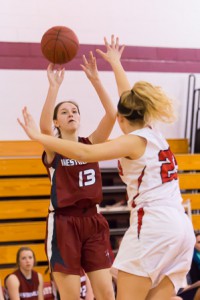 Westborough’s Haley Brown (#13) shoots from the corner while Hudson’s Renee Baker attempts to block her shot.