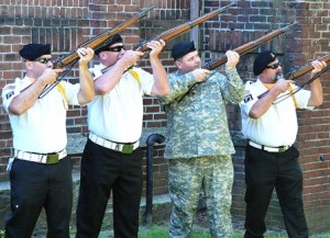 Members of AMVETS Post 208 and the 26th Signal Company of the Massachusetts National Guard fire a gun salute.