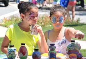 After getting their faces painted, Bruna Oliveira, 7, and Maria Silva, 6, choose which sand art design they's like to create.