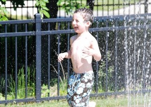 Gabriel Jacobs, 3, is happy to get relief from the heat in the Splash Pad.
