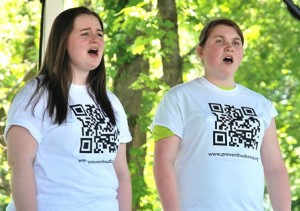 Singing at the Cellucci Park gazebo are Brooke Mega and Lexi Hire of Camerata, a Hudson High School a cappella group.