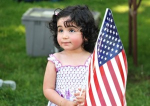 Lara Avelar, 2, waves an American flag she received as a souvenir of the festival.