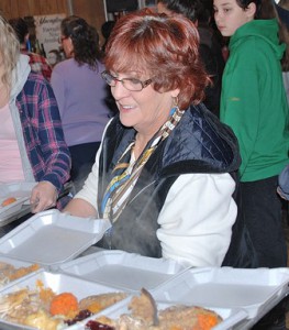 Beverly Rivers, president of Hudson AMVETS Auxiliary Post 208, helps prepare meals.