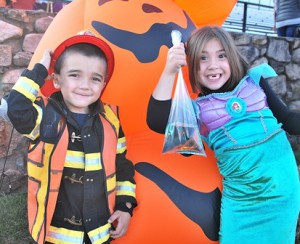 Posing with a stack of inflatable jack-o-lanterns are the Blood siblings: Brady, 5, dressed as Fire Chief Blood, and Dancia, 7, as Ariel of the film “The Little Mermaid.”