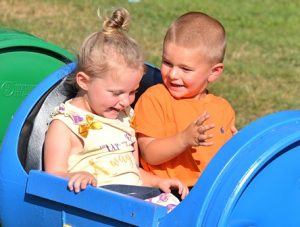 Three-year-old friends Kylee Cheney and Bryce Douglass take a trackless train ride together. Photo/Ed Karvoski Jr. 