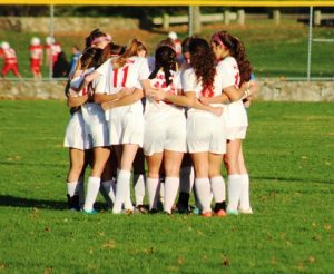 The Hudson Girls Varsity soccer team gathers during an injury timeout during a game against Clinton. 