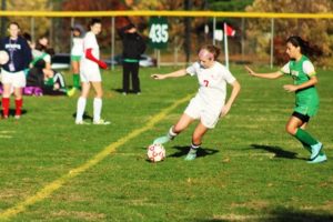 Nadia Doherty dribbles up the sideline as a Clinton player chases her. 