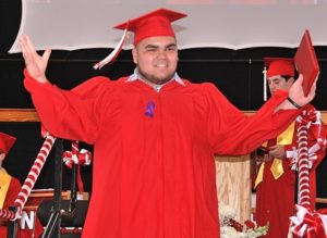Richard Fonseca Jr. happily walks off the platform with his diploma in hand.