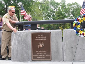 Quartermaster Jim Cabral of VFW Post 1027 unveils the bronze plaque on the Capt. Seth R. Michaud Memorial Bridge. 