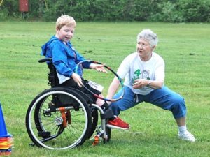 Logan Anketell, 8, prepares to toss a hoop assisted by adaptive physical education teacher Nancy Hudson. 