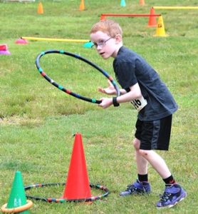 Caden Crogan, 7, aims a hoop toward a cone.