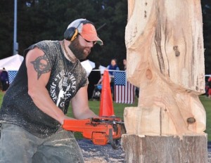 “The Machine” Jesse Green carves a wood sculpture of a turtle