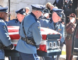 State troopers from the Charlton barracks carry the flag-draped casket.