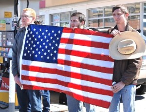 Residents display the American flag as the procession travels on Main Street.