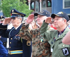 Saluting as the American flag is risen are (l to r) Dick Bonazzoli, Army combat engineer veteran of the Korean War; Bill Higgins, Air Force veteran of the Korean War; and Steve Arsenault, Army combat medic veteran of the Vietnam War. 
