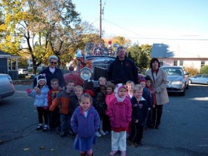 Arlene Room (left, back row), Firefighter Rich Hubert (center), and Laurie Santarpio (right) taught the children of Hudson's First Steps Childcare Center how to stay safe during a fire. (Photo/submitted)