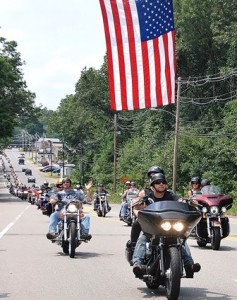 Riders pass under the American flag on Coolidge Street. 