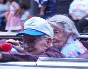 Hudson native Allan Johnson waves to the crowd as the parade passes through the Hudson rotary. Johnson and his wife, Kay, were two of the seven grand marshals named by the Hudson Historical Society for the parade. Photo/Dakota Antelman 