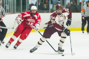 Algonquin’s Justin O’Connell (#22) brings the puck up the ice while being pursued by Hudson’s Adryon Miranda (#12). 