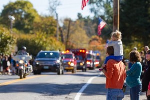 A young resident gets a good view of Southborough's emergency vehicles leading the parade down Main Street. 