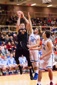 Marlborough’s Chris Doherty goes up for a shot while being guarded by Medfield’s Evan Howells.