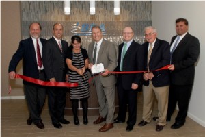 Lauren Baker, PhD, PE, (center), the president and CEO of Boston Biomedical Associates, is joined by employees of the company as well as city officials in celebrating the grand opening of the company’s new headquarters in Marlborough.    Photo/courtesy Sharon Lawler, Townson Photography 
