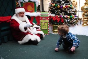 Jacob Manucci plays with a car while Santa looks on. 