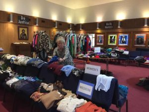 Volunteer Anita Phelan of Marlborough folds donated sweaters before the doors open for the   2016 Fall Clothing Giveaway at St. Stephen Lutheran Church. (Photo/submitted)