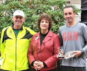 Jim McKenna, president of the Highland City Striders (HCS), and Susanne Morreale Leeber, president and CEO of the Marlborough Regional Chamber of Commerce, present trophies to Michael Clements of Marlborough for finishing first overall in 4:33 in the Main Street Mile. Clements also placed first overall last year. First-place female was Sudbury native Lauren Leslie visiting from Warwick R.I., who finished in 5:55. This year, 127 runners ranging in age from 4 to 69 participated. The race is organized by HCS.