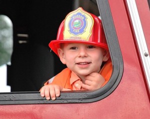 Luke Walsh, 3, peers from a Hudson Fire Department truck.
