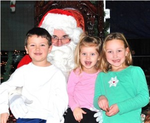 Meeting Santa are (l to r) A.J. Leandres, 5, his sister, Lexi, 2, with their cousin, Kendall Jordan, 5. Some adult guests noticed a resemblance between Santa and City Councilor Don Landers.