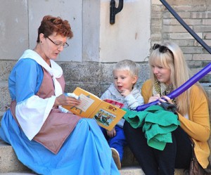 Marlborough Historical Society member Debby Foley reads a story to Hunter McKelvey, 3, and his mother, Lindsey.