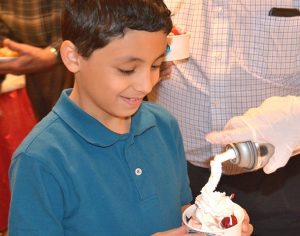 George Morcos, 8, gets his ice cream sundae topped with whipped cream.