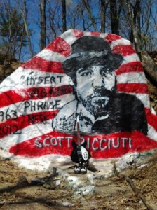 The 2013 rock painting memorializing Scott Ricciuti with his guitar and his shoes.