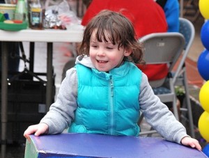Alison LaRose, 4, begins stacking colorfully painted boxes, one of several children’s activities offered by Marlborough Downtown Village.