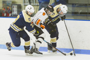 Marlborough’s Ryan MacGlashing fights off Shrewsbury’s Tom Abbott (left) and Pat Kelly (right) as he tries to make a play for the puck. 