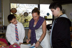 Fourth-grade teacher Jaime Miller, shown here working with students Brendan Bongiorno and John Sordillo, was one of five staff “brides” at Formal Day.