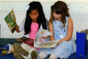Second-graders Ariana Colindres and Rebecca McKinnon don’t let their formal wear keep them from reading a few good books.