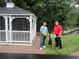 Patti Foti’s sons, Christopher (l) and Anthony, stand next to gazebo dedicated to their mother. 