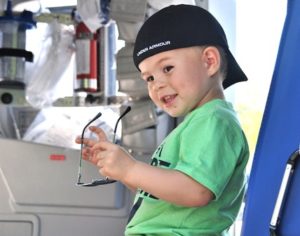 Ben Croft, 2, removes his aviator sunglasses while seated in a LifeFlight helicopter. 